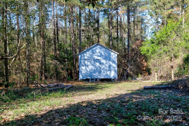 view of shed with a wooded view