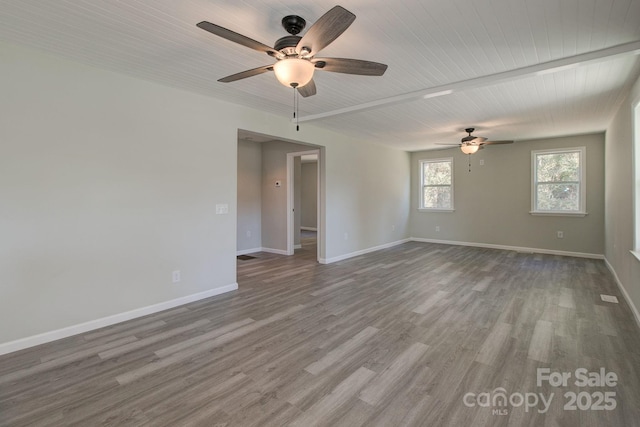 unfurnished room featuring wood ceiling, wood finished floors, baseboards, and ceiling fan