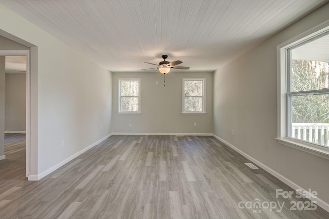 spare room featuring wood finished floors, visible vents, baseboards, ceiling fan, and wooden ceiling