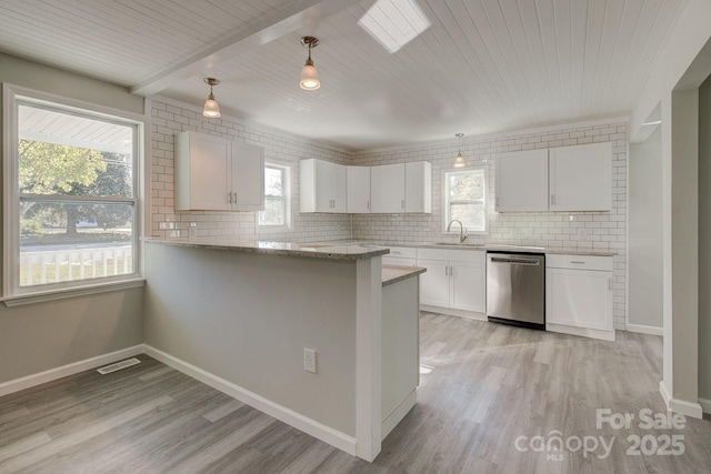 kitchen featuring decorative backsplash, dishwasher, visible vents, and a sink