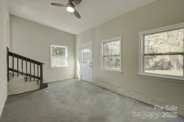 entryway with stairway, concrete floors, a ceiling fan, and vaulted ceiling