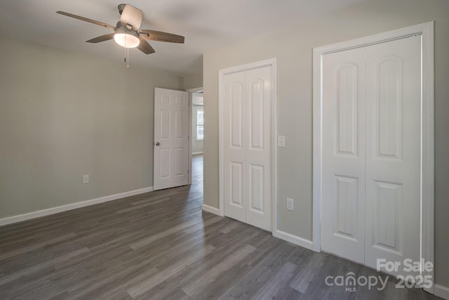 unfurnished bedroom with ceiling fan, baseboards, and dark wood-style flooring