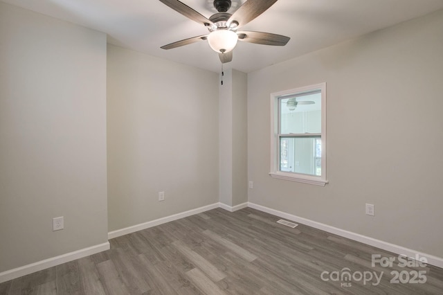 spare room with visible vents, baseboards, ceiling fan, and wood finished floors