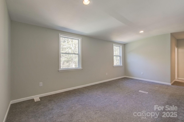 spare room with recessed lighting, baseboards, and dark carpet