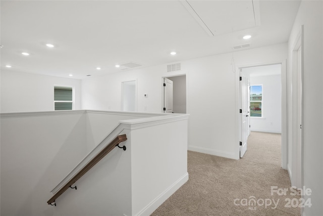 hallway with light colored carpet