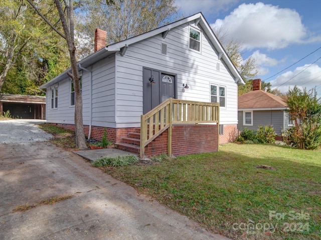 bungalow-style home with a front lawn