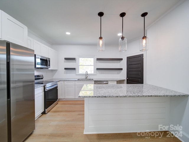 kitchen featuring stainless steel appliances, white cabinetry, decorative light fixtures, and light stone counters