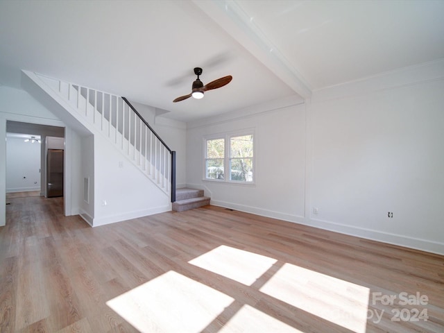 unfurnished living room with ceiling fan, light hardwood / wood-style floors, and beam ceiling