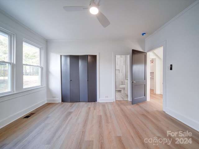 unfurnished bedroom featuring a closet, ornamental molding, ensuite bath, ceiling fan, and light hardwood / wood-style flooring