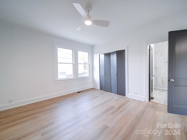 unfurnished bedroom featuring light hardwood / wood-style floors, ceiling fan, and a closet