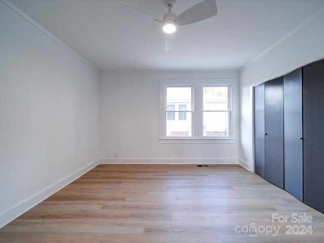 unfurnished bedroom with light hardwood / wood-style floors, ceiling fan, a closet, and crown molding