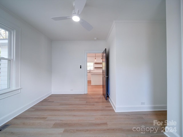 unfurnished room featuring ceiling fan, ornamental molding, and light hardwood / wood-style flooring