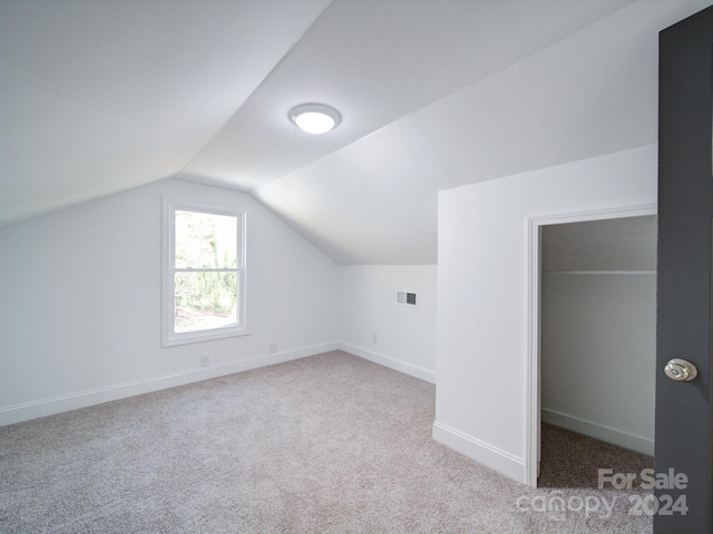 bonus room featuring light colored carpet and lofted ceiling