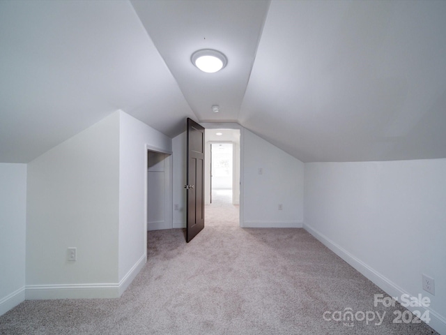 bonus room featuring vaulted ceiling and light carpet