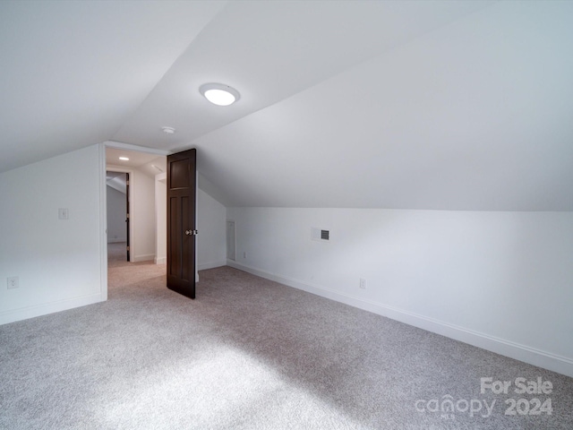 bonus room with light carpet and lofted ceiling