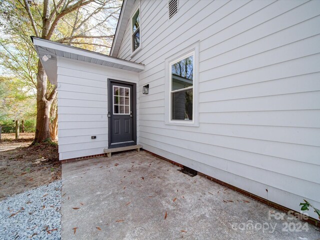 view of exterior entry with a patio