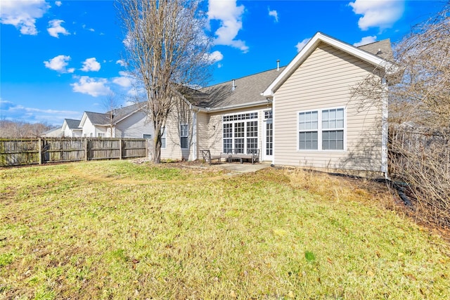 back of house with a lawn and a patio