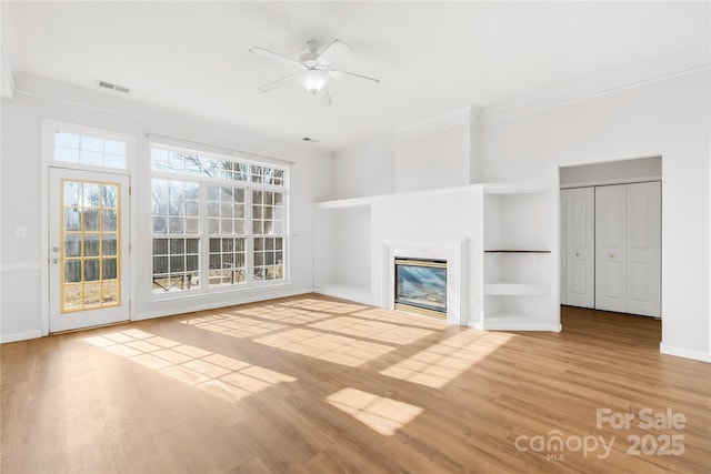 unfurnished living room featuring crown molding, ceiling fan, and wood-type flooring