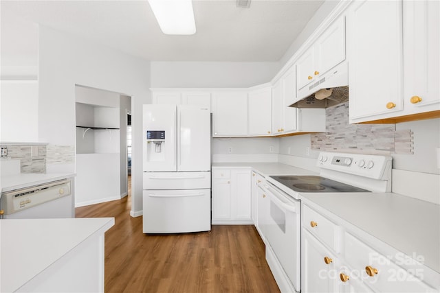 kitchen with white cabinetry, backsplash, white appliances, and wood-type flooring