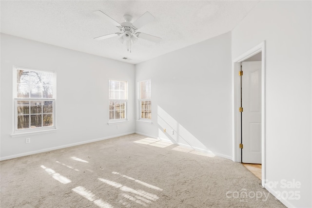 carpeted spare room featuring ceiling fan and a textured ceiling