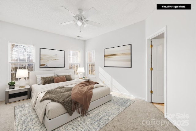 bedroom featuring light carpet, a textured ceiling, and ceiling fan