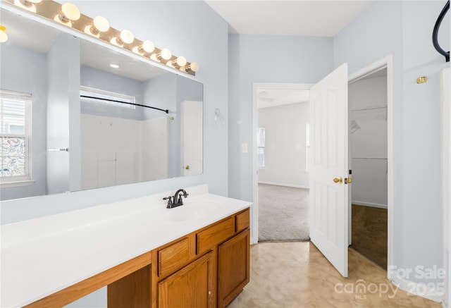 bathroom featuring walk in shower and vanity