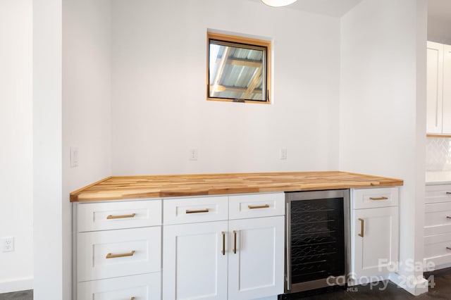 bar with white cabinetry, butcher block countertops, and wine cooler