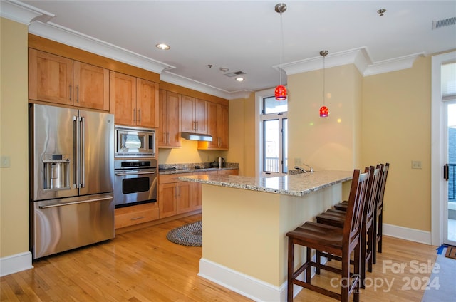 kitchen featuring light stone counters, stainless steel appliances, decorative light fixtures, light hardwood / wood-style floors, and kitchen peninsula