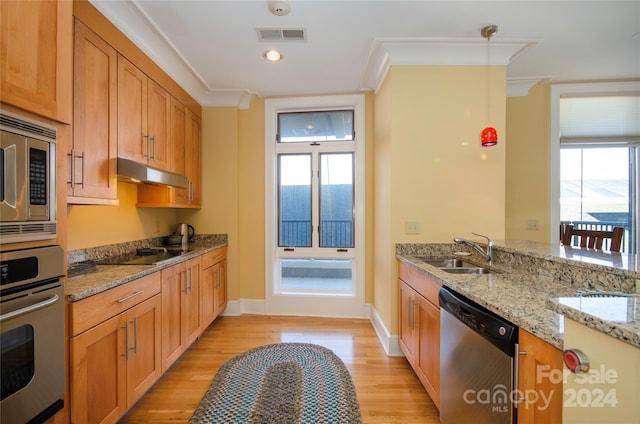 kitchen featuring sink, appliances with stainless steel finishes, light stone countertops, light hardwood / wood-style flooring, and crown molding