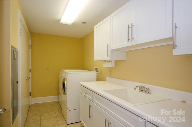 laundry room with washing machine and dryer, cabinets, sink, and light tile patterned floors