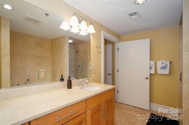 bathroom featuring vanity, tile patterned flooring, and a shower with shower door