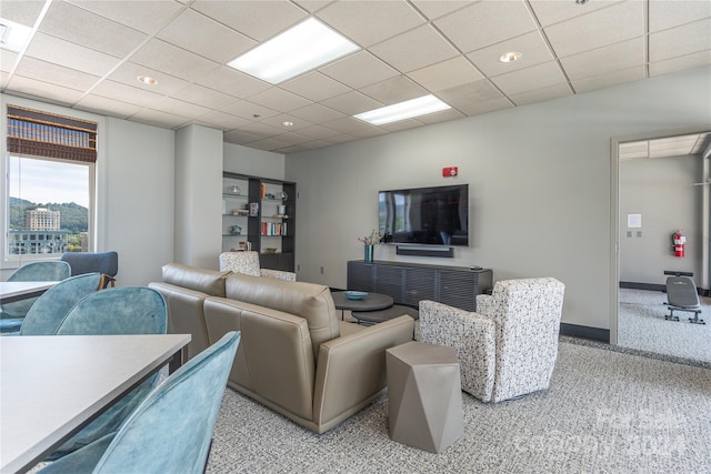 living room featuring a paneled ceiling and light carpet