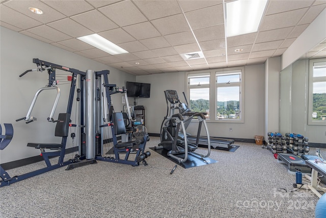 workout room with a paneled ceiling and carpet floors