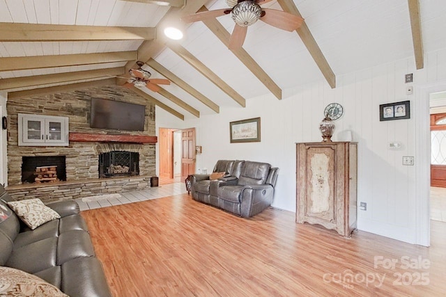 living room featuring ceiling fan, vaulted ceiling with beams, light hardwood / wood-style flooring, wood ceiling, and a stone fireplace