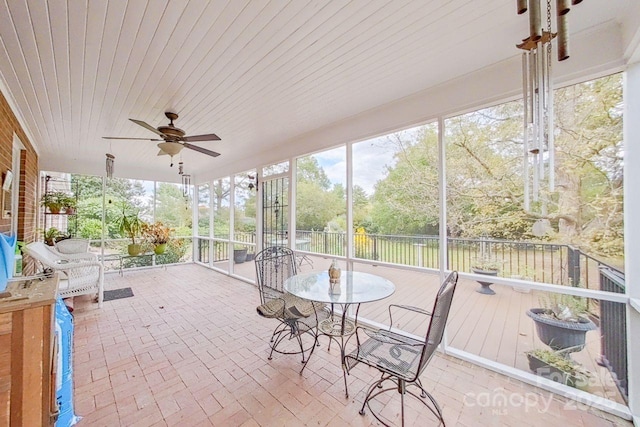 unfurnished sunroom featuring ceiling fan