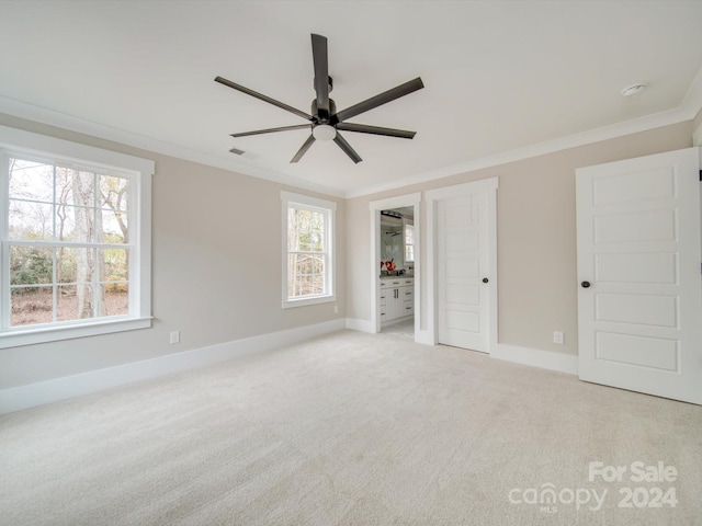 unfurnished bedroom featuring light carpet, ceiling fan, and crown molding