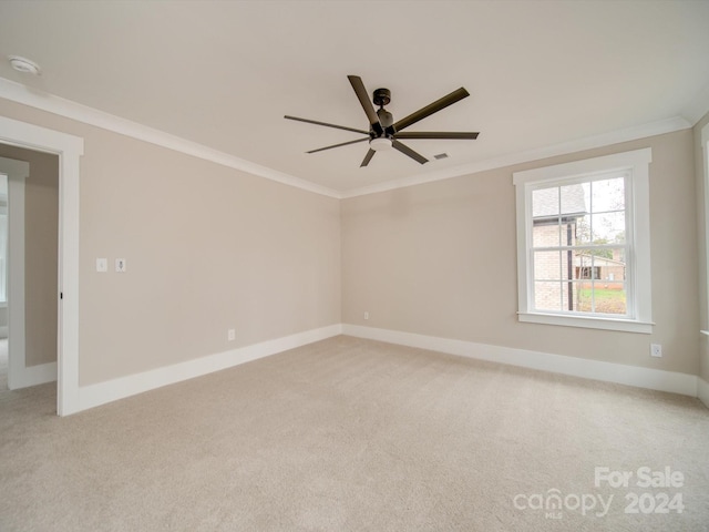 empty room featuring ceiling fan, light colored carpet, and ornamental molding