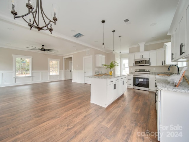 kitchen with appliances with stainless steel finishes, pendant lighting, white cabinets, dark hardwood / wood-style floors, and a kitchen island