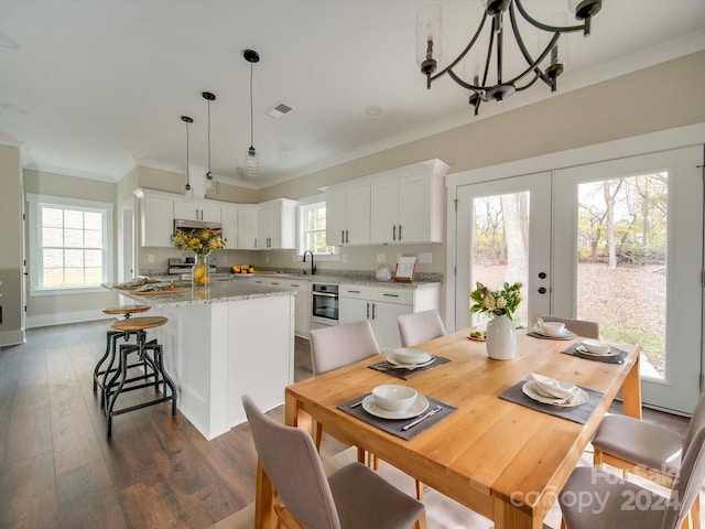 dining space featuring plenty of natural light, dark hardwood / wood-style flooring, and crown molding