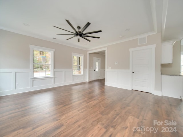 unfurnished living room with dark hardwood / wood-style floors, ceiling fan, and ornamental molding