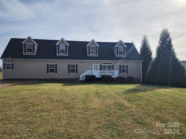 cape cod house featuring a front lawn and a deck