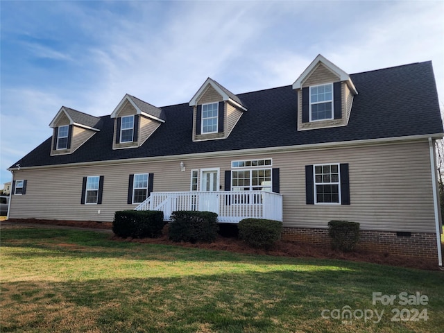 cape cod home with a front yard and a wooden deck