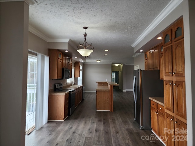 kitchen featuring appliances with stainless steel finishes, hanging light fixtures, crown molding, a kitchen island, and dark wood-type flooring