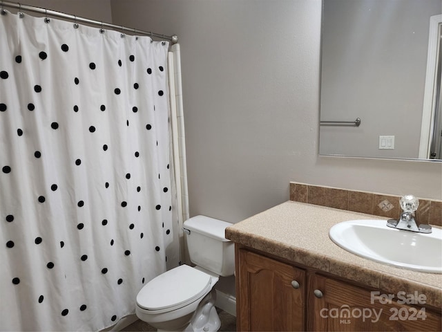 bathroom featuring curtained shower, vanity, and toilet