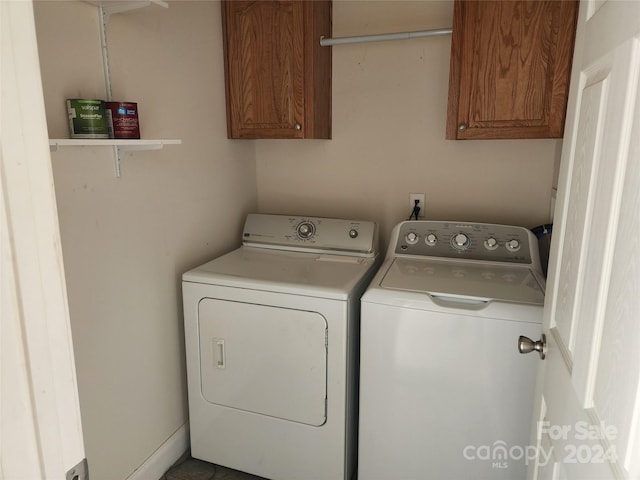 laundry area with washing machine and dryer and cabinets