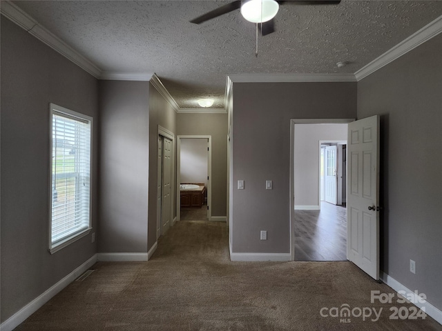 unfurnished bedroom with ceiling fan, a textured ceiling, carpet flooring, and ornamental molding