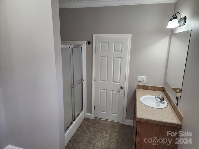 bathroom featuring vanity, an enclosed shower, and ornamental molding