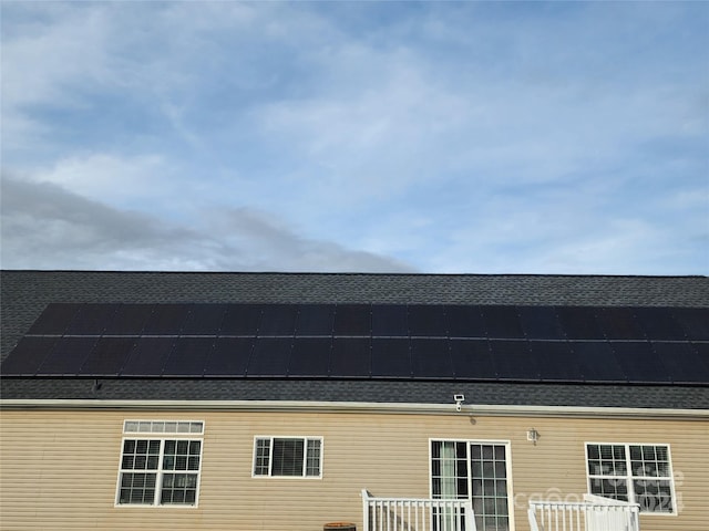 view of side of property featuring solar panels