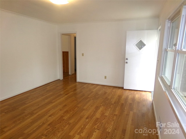 unfurnished room with ornamental molding and hardwood / wood-style flooring