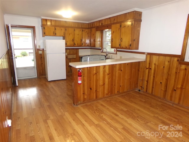 kitchen with kitchen peninsula, light hardwood / wood-style flooring, a healthy amount of sunlight, and white fridge